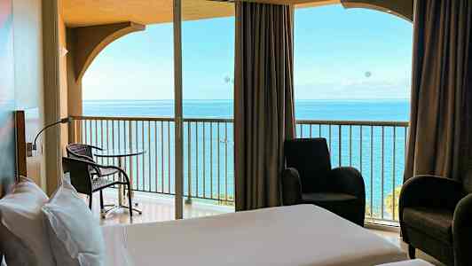 Hotelværelse med udsigt til havet fra altanen. (AI-genereret tekst)