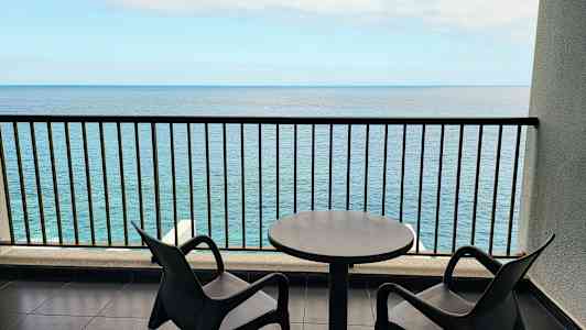 To stole og et bord på en altan med havudsigt. (AI-genereret tekst)