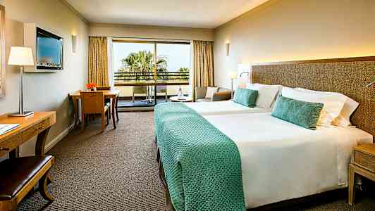 Hotelværelse med to senge og balkon. (AI-genereret tekst)