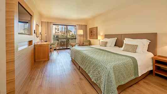 Hotelværelse med dobbeltseng og altan. (AI-genereret tekst)