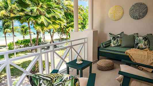 En terrasse med udsigt over palmer og stranden. (AI-genereret tekst)