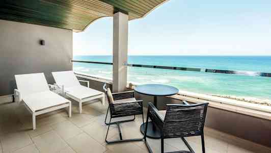 Altan med liggestole og udsigt over havet. (AI-genereret tekst)