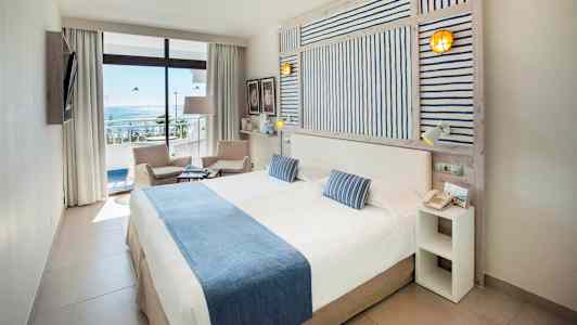 Dobbeltværelse med havudsigt, møbler i lyse farver. (AI-genereret tekst)