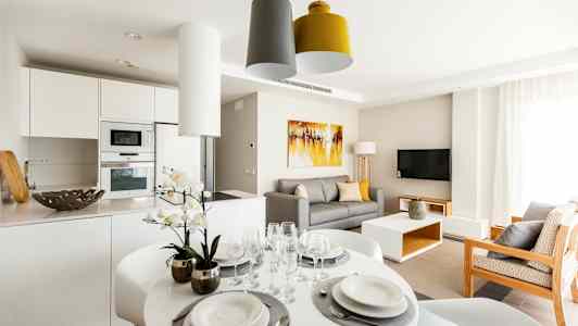 En moderne stue med køkkenområde, spisebord og sofa. (AI-genereret tekst)