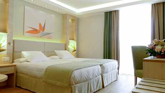 Hotelværelse med en dobbeltseng, dekorationer og et vindue med gardiner. (AI-genereret tekst)