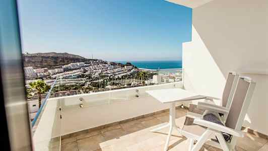 En altan med udsigt over havet og bygninger. (AI-genereret tekst)