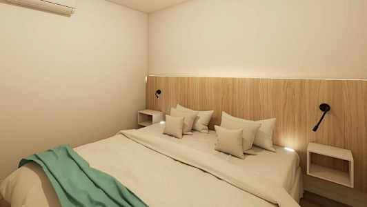 Et soveværelse med en dobbeltseng, en træpanel som hovedgærde og vægmonterede lamper. Sengen er redt med hvidt sengetøj og et grønt tæppe. (AI-genereret tekst)