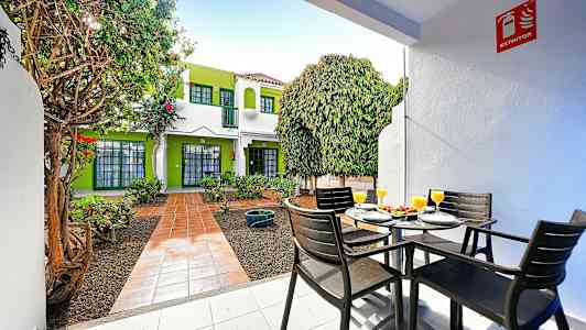 Udendørsområde med siddepladser og frodig omgivelser. (AI-genereret tekst)