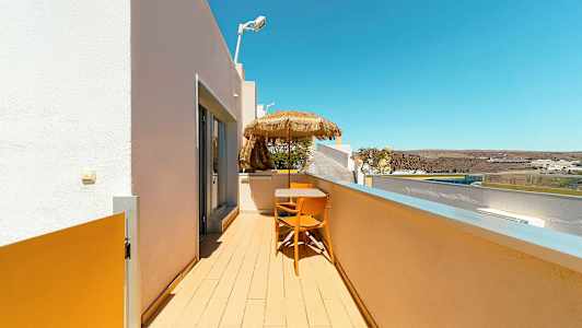 Altanen med bord, stole og parasol med udsigt over omgivelserne. (AI-genereret tekst)