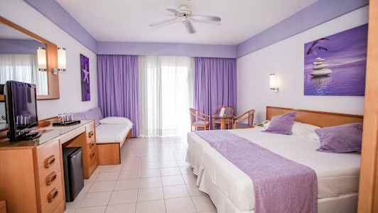 Hotelværelse med en stor seng, en enkeltseng, et bord med stole og en TV-bænk. (AI-genereret tekst)