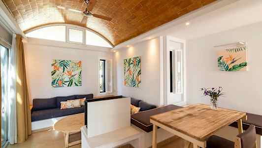 En indretning med træbord, sofa og vægdekorationer med plantemotiver. (AI-genereret tekst)