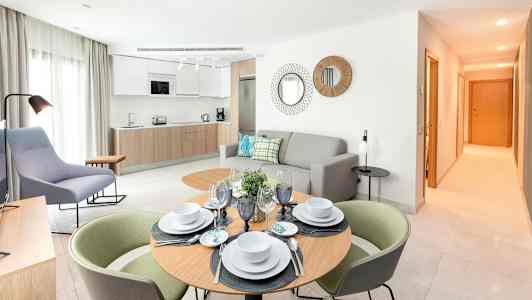 Moderne indrettet stue med køkken og spisebord. (AI-genereret tekst)