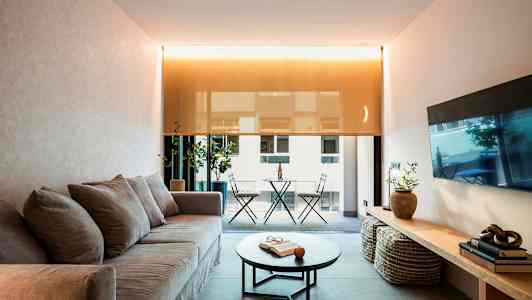 Stue med sofa, sofabord og udsigt til altan. (AI-genereret tekst)