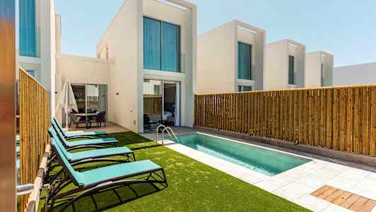 Private villaer med pool og liggestole. (AI-genereret tekst)