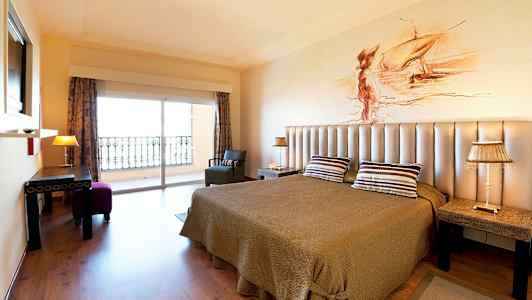 Værelse med dobbeltseng, loftlampe og udsigt til altan. (AI-genereret tekst)