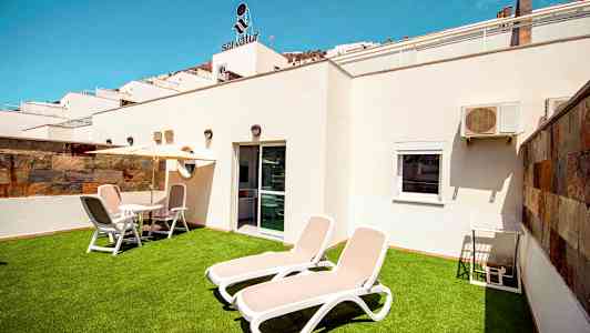 Privat terrasse med liggestole og havemøbler. (AI-genereret tekst)