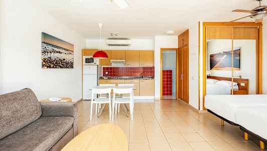 Et moderne hotelværelse med åbent køkken og soveplads. (AI-genereret tekst)