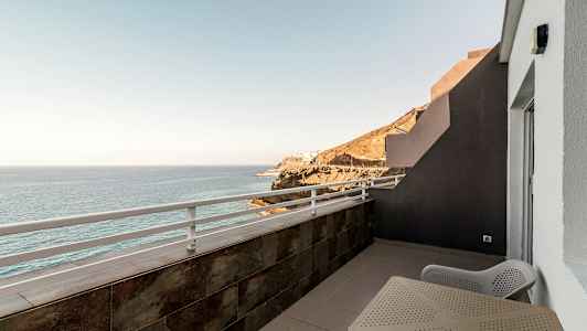 Altan med udsigt over havet og klipper. (AI-genereret tekst)