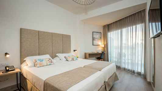 Moderne hotelværelse med dobbeltseng, skrivebord og altan. (AI-genereret tekst)