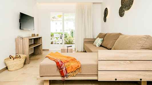 Indretningen i en lys stue med en beige sofa og en bred terrassedør. (AI-genereret tekst)