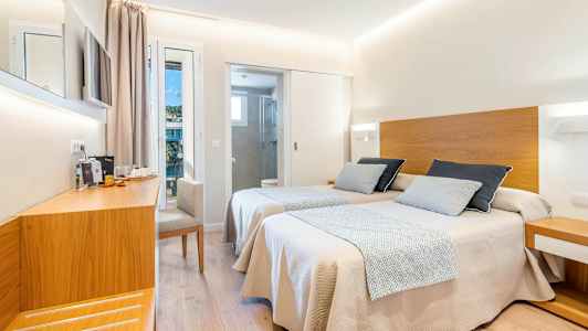 Et hotelværelse med to enkeltsenge med trædetaljer, en arbejdsplads og adskilt badeværelse. (AI-genereret tekst)