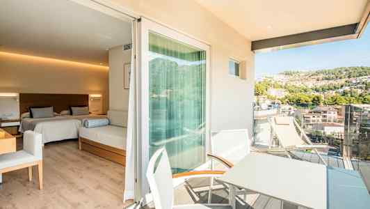 Et hotelværelse med to senge og en siddemøbel, med en tilhørende balkon hvor der er bord og stole samt udsigt over en frodig bakke. (AI-genereret tekst)