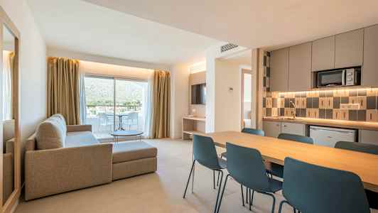 En moderne lejlighed med stue, spiseområde og køkken. Store glasdøre fører ud til en altan. (AI-genereret tekst)