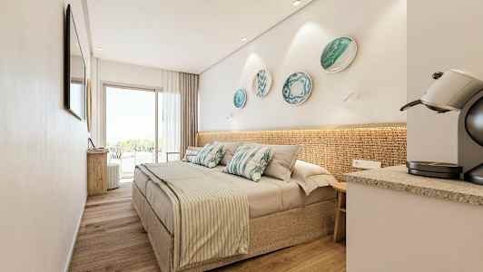 Et moderne hotelværelse med en dobbeltseng, dekorative pyntefade på væggen, en kaffemaskine og store glasdøre, der fører til en altan. (AI-genereret tekst)