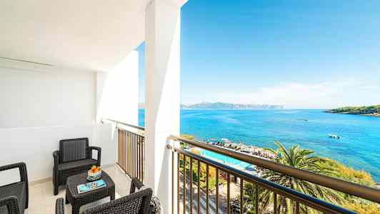 En altan med siddepladser vendt mod havet. (AI-genereret tekst)