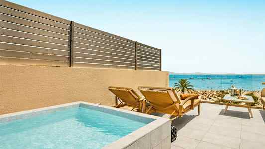 En terrasse med en lille pool, liggestole og et bord med havudsigt. (AI-genereret tekst)