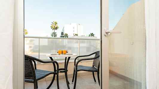 En altan med to stole og et bord, hvor drikkevarer er serveret. (AI-genereret tekst)