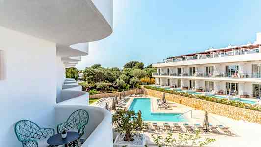 Billedet viser et feriested med pool og liggestole samt altaner med siddepladser. (AI-genereret tekst)