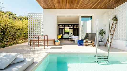 En moderne terrasse med pool, siddepladser og haveudsmykning. (AI-genereret tekst)