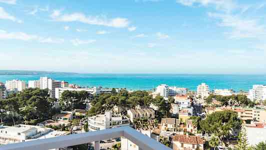 Udsigt over en kystby med bygninger, træer og havet i baggrunden. (AI-genereret tekst)