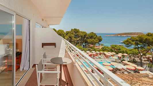 Altan med siddepladser, udsigt til poolområde og hav. (AI-genereret tekst)