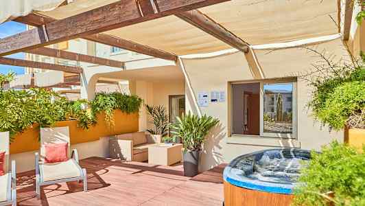 Terrasse med udendørsmøbler, planter og en boblebad. (AI-genereret tekst)