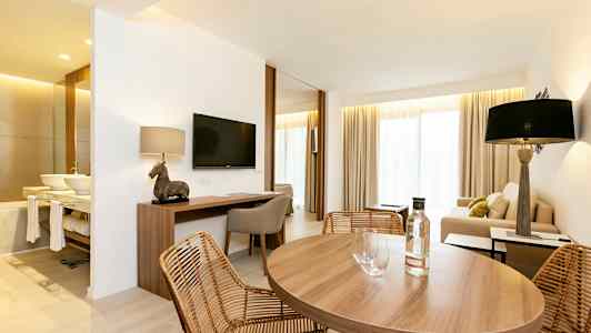 Værelse med spisebord, sofahjørne og skrivebord. (AI-genereret tekst)