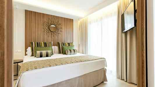 Moderne hotelværelse med dobbeltseng, vægdekoration og TV. (AI-genereret tekst)