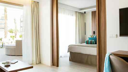 Moderne hotelværelse med lys indretning, meget dagslys og en komfortabel seng. (AI-genereret tekst)