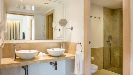 Badeværelse med to håndvaske og bruser. (AI-genereret tekst)