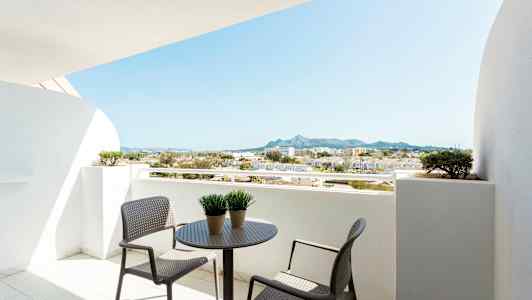 Altan med bord og stole, udsigt over omkringliggende bygninger og bjerge. (AI-genereret tekst)