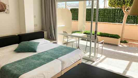 Moderne indrettet hotelværelse med seng og udsigt til en privat terrasse. (AI-genereret tekst)