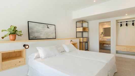 Et lyst hotelværelse med en dobbeltseng og træindretning. (AI-genereret tekst)