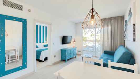 En stue med blå møbler, en hængende lampe og en åben altan. (AI-genereret tekst)