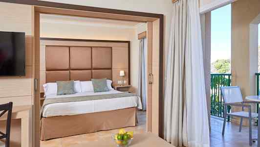 Hotelværelse med dobbeltseng, siddeområde og altan. (AI-genereret tekst)