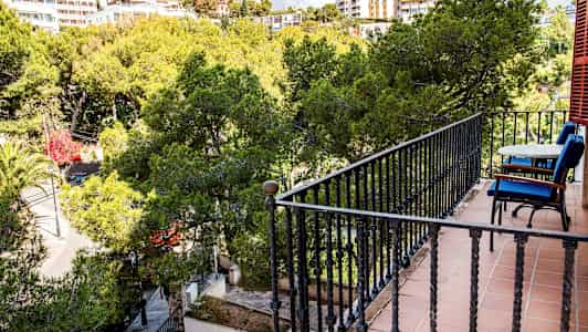 Altan med bord og stole med udsigt til frodig beplantning. (AI-genereret tekst)