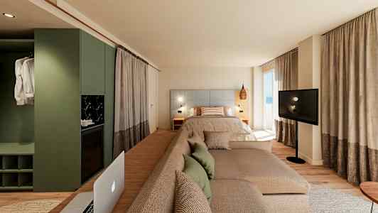 Moderne hotelværelse med seng, sofa og tv foran store vinduer. (AI-genereret tekst)