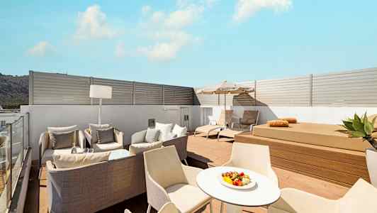 Moderne tagterrasse med liggestole, siddeområde og bord. (AI-genereret tekst)