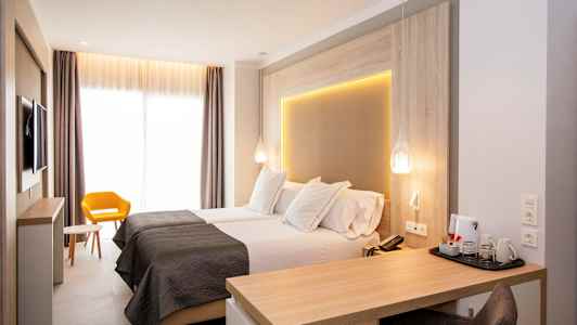 Moderne hotelværelse med to enkeltsenge, skrivebord og gul stol. (AI-genereret tekst)