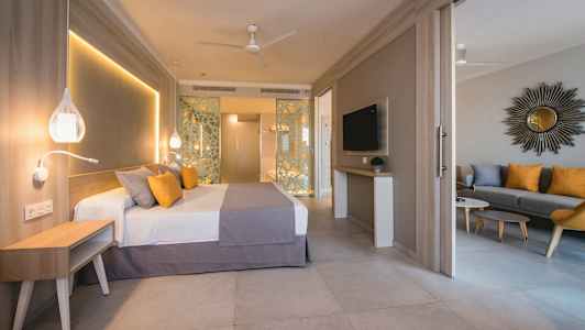 Hotelværelse med seng, siddeområde og TV. (AI-genereret tekst)